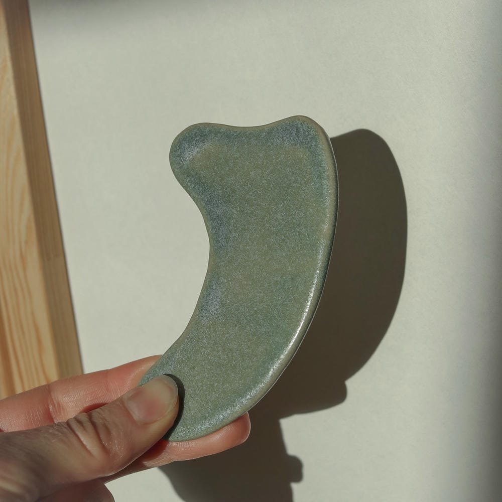 Pierre de massage Gua Sha artisanale en céramique pour une peau rebondie. Fabriquée en France